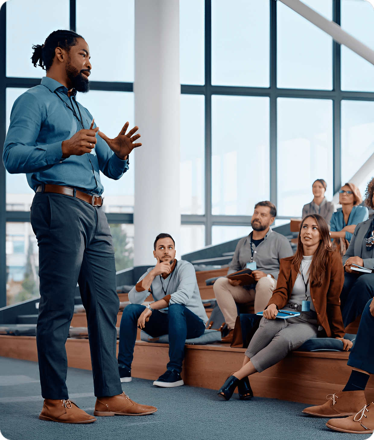 Man speaking to seated audience in auditorium.