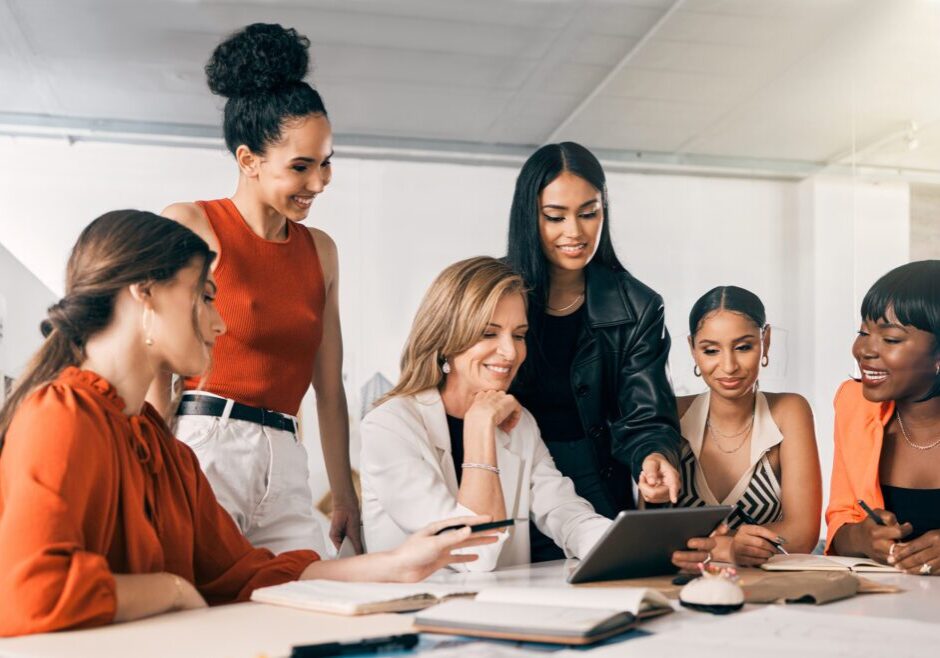 Shot of a group of businesswomen using a digital tablet together at work Women collaborating around a tablet in office.